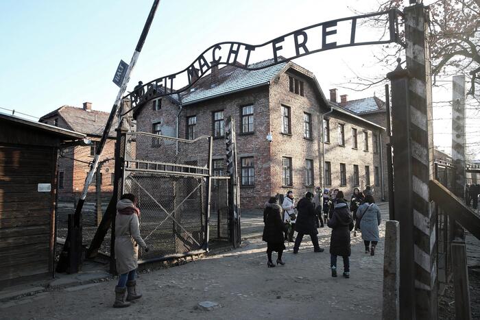 epa08048621 Visitors walks past the gate with inscription 'Arbeit Macht Frei' to the Auschwitz-Birkenau Memorial and Museum of former Nazi German concentration and extermination camp in Oswiecim, Poland, 06 December 2019. Polish Prime Minister Mateusz Morawiecki and German Chancellor Angela Merkel will visit the Memorial ahead of 75th anniversary of the death camp's liberation.  EPA/LUKASZ GAGULSKI POLAND OUT